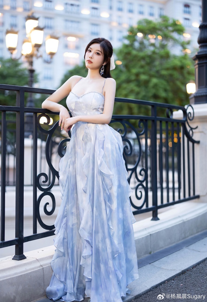 暮色漫过欧式建筑的楼宇，浅蓝纱裙裹挟着傍晚温柔晚风。街边暖灯悄悄次第亮起，邂逅一